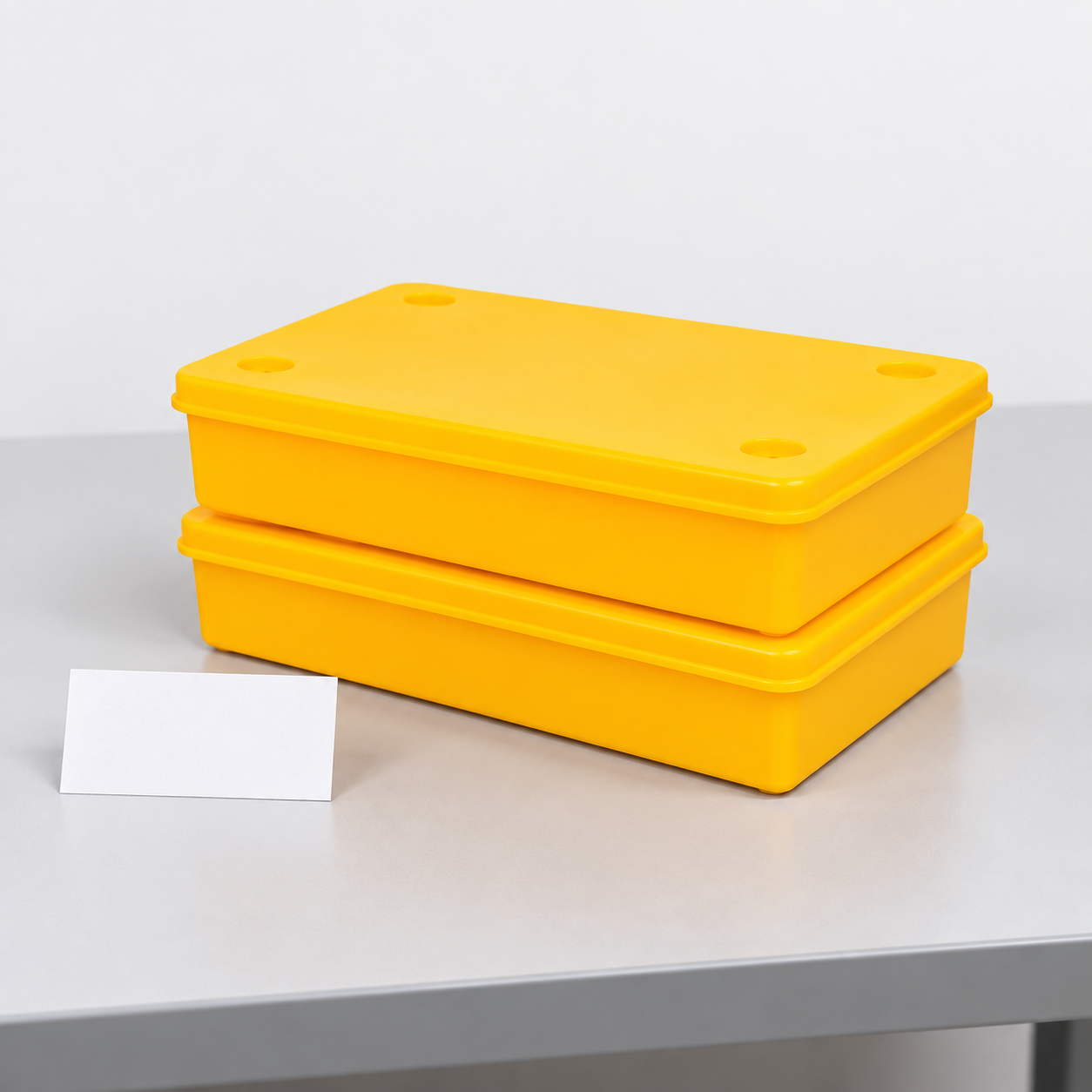 Two yellow lidded ESD bins aligned in a short stack on a flat test table