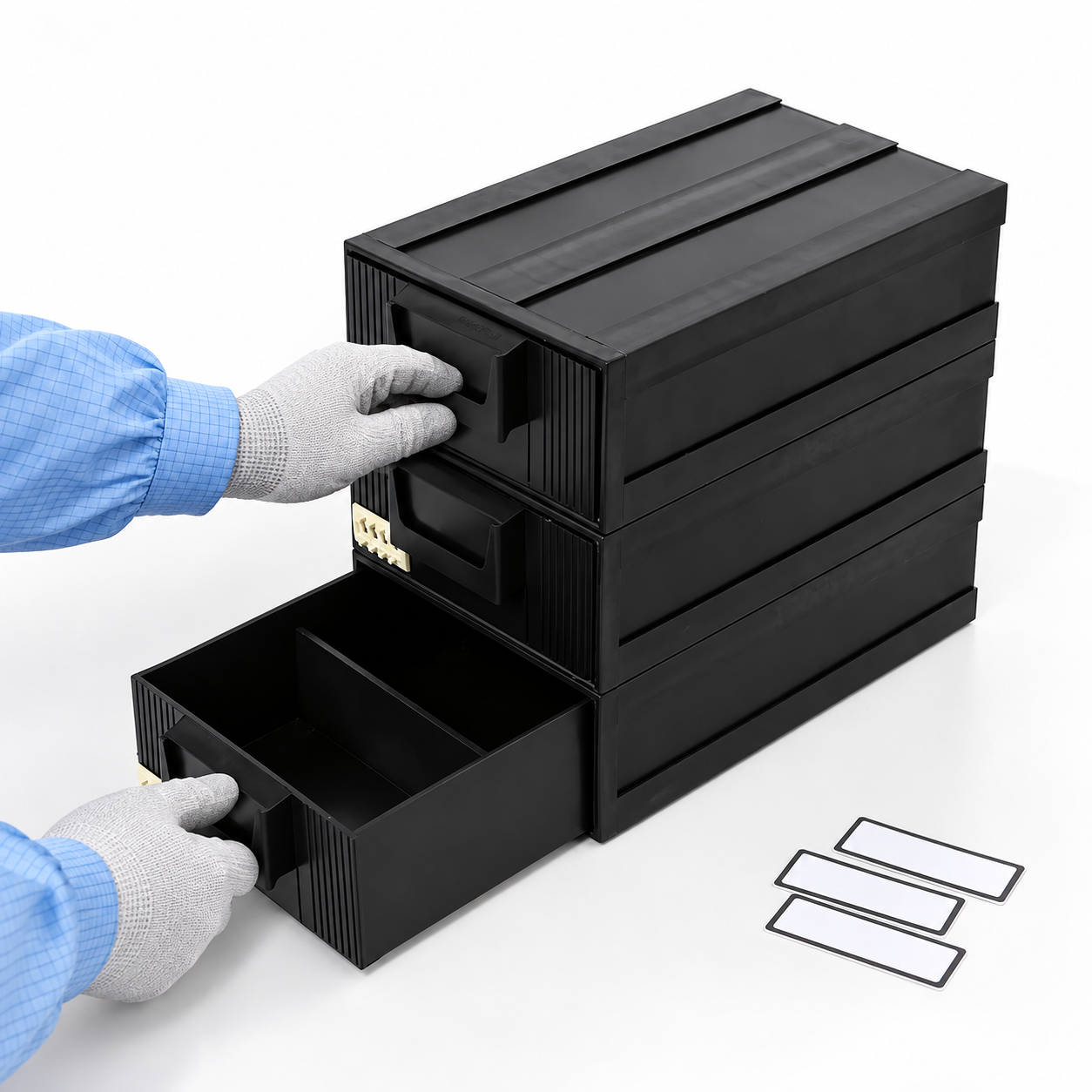 Gloved operator checking the handle and closure of a black three-drawer ESD cabinet