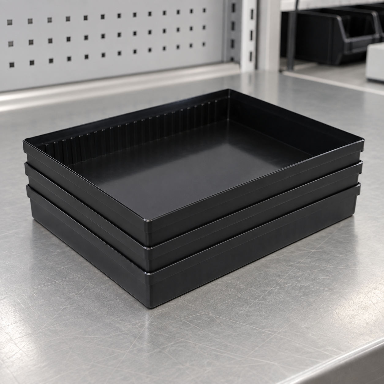 Three empty black SWESD-style ESD trays nested level for stack-fit inspection