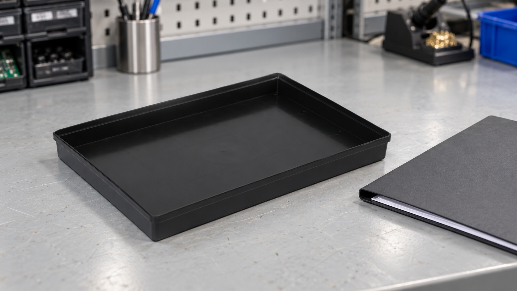 Shallow black SWESD ESD tray beside a plain procurement folder