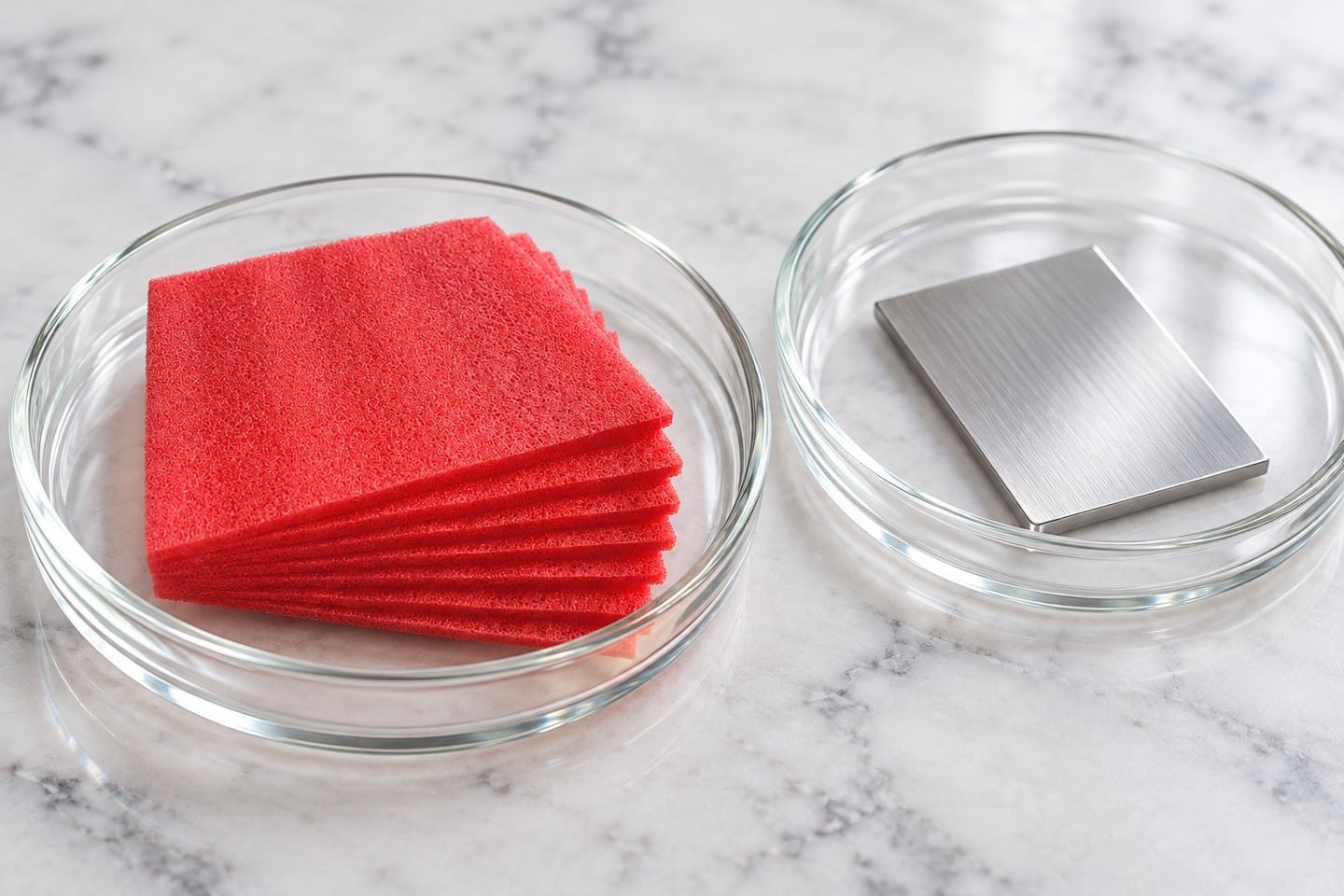 Pink-red SWESD foam and a separate clean metal specimen in sample dishes