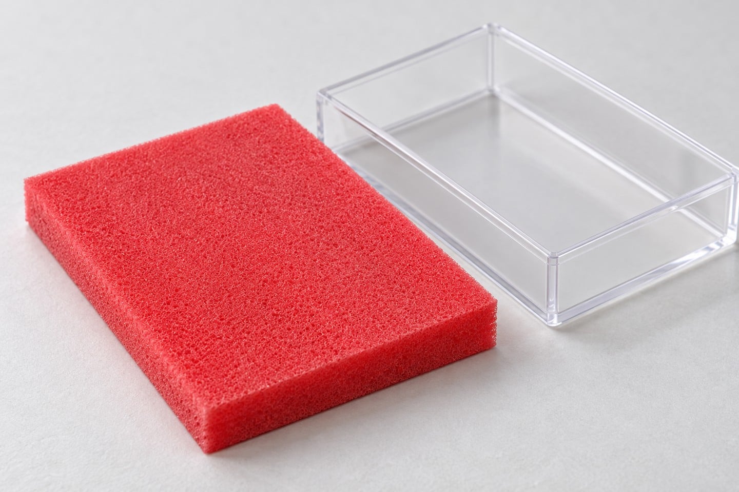 Pink-red SWESD foam edge and porous texture beside a specimen holder