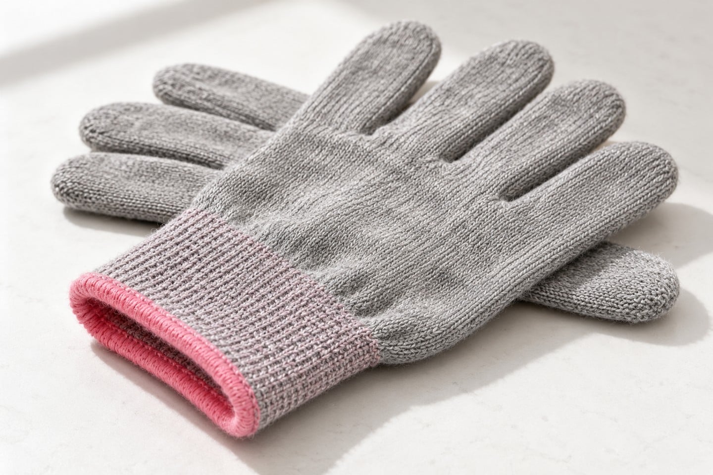 Gray SWESD glove knit and pink ribbed cuff prepared for condition review