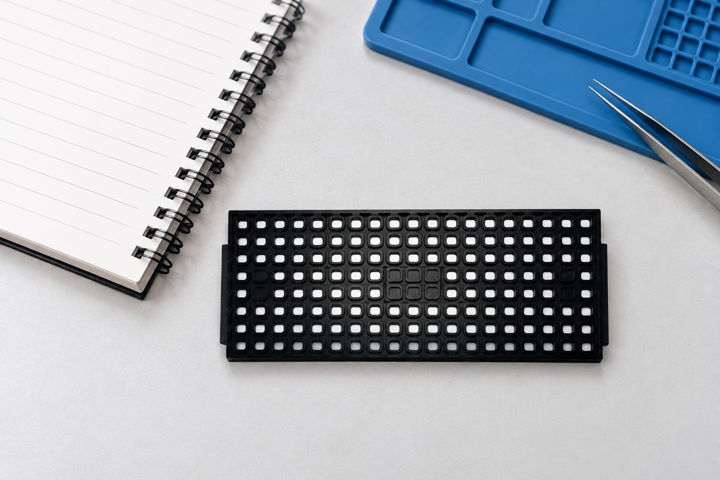 Black SWESD matrix tray beside an engineering setup notebook
